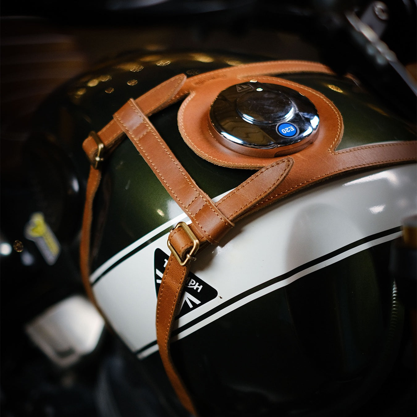Close-up of a motorcycle helmet with a brown strap on a blurred background