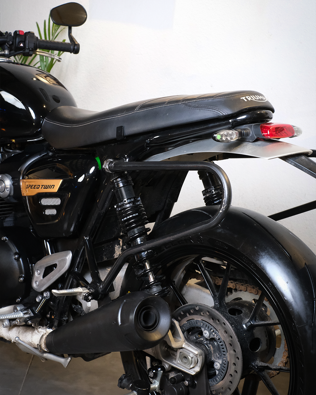 Close-up of a black motorcycle with visible branding on a white background