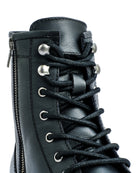 Close-up of a black leather boot with laces on a white background