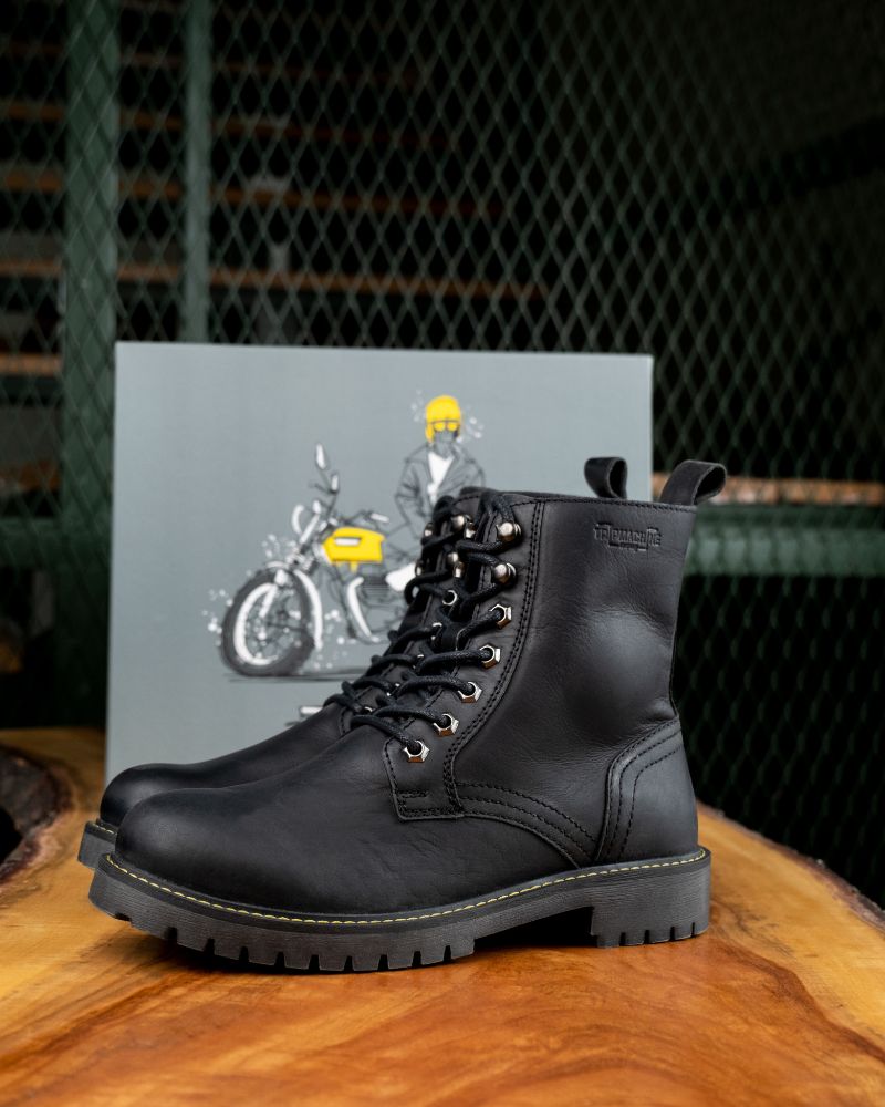 Complete side view of black color handmade genuine leather derby boots with ankle, toe and heel protector for bikers with shoe box in the background