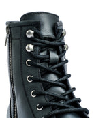 Close-up of a black leather boot with laces on a white background