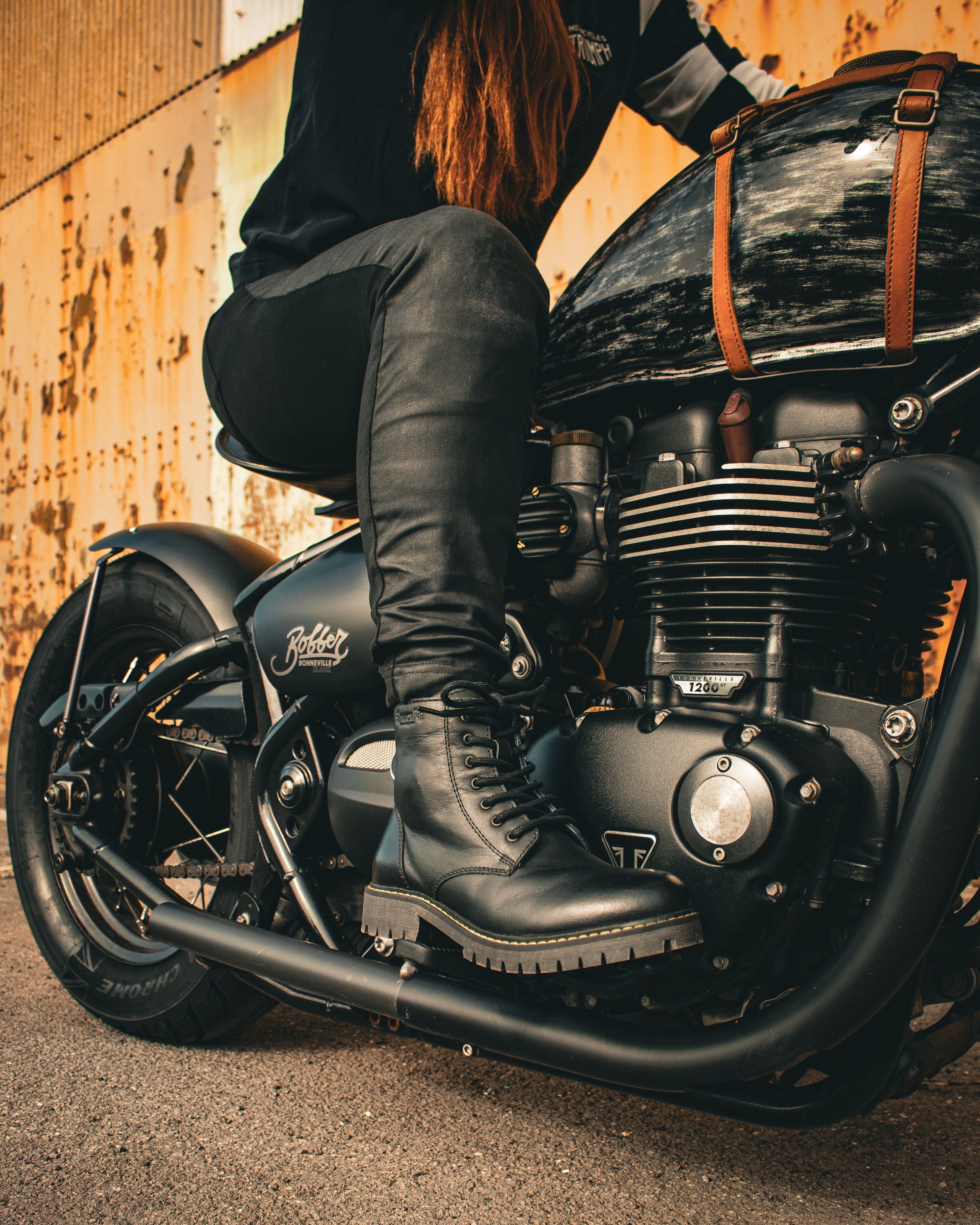Person sitting on a motorcycle with a rustic background